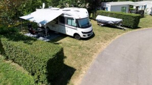 A recreational vehicle (RV) parked in a grassy area with a covered picnic table nearby. - Cosy Mobile Home 6 Pers with Terrace (Radonvilliers)