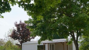 A small, single-story mobile home with a porch and a covered outdoor area. - Cosy Mobile Home 6 Pers with Terrace (Radonvilliers)