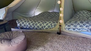 A tented room with two beds, each with patterned bedding, a small table, and a bean bag chair. - Comfortable 2-Bedroom Chalet with Terrace in Vébron (Vebron)