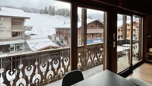 A room with a large window overlooking a snowy village.