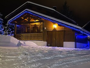 Eine Holzhütte mit Balkon, umgeben von Schnee.