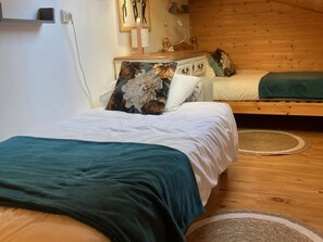 Un dormitorio con una cama, un tocador y un cabecero de madera.