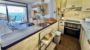 Eine moderne Küche mit Meerblick, ein Essbereich mit Aussicht und ein kleiner Balkon.