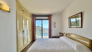Ein Hotelzimmer mit einem großen Bett, Meerblick und einem Balkon.