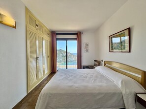 A hotel room with a large bed, a view of the sea, and a balcony. - Apartment in Roses with private parking, 2 bedrooms and large terrace (Roses)