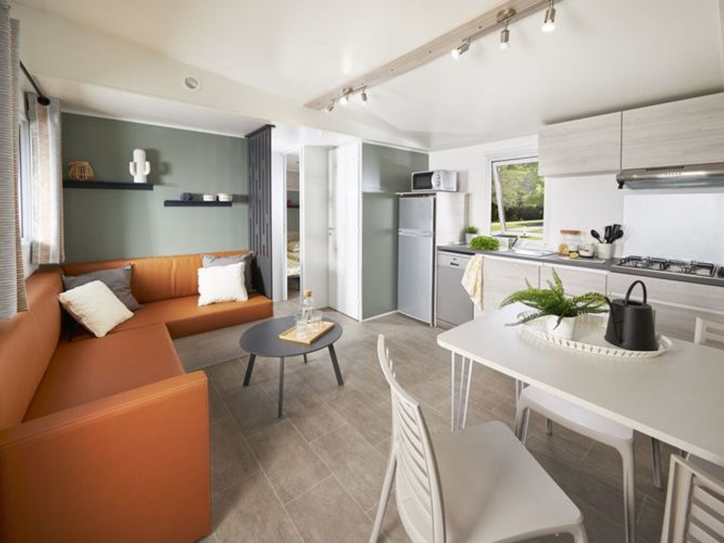 A modern living room with a sofa, coffee table, and dining area.