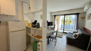 Quarto de hotel compacto com cozinha compacta, área de refeições e sofá.