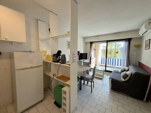 A compact hotel room with a kitchenette, a dining area, and a sofa. - Comfortable & Air-Conditioned T2 Cabin - Argelès-sur-Mer (Argelès-sur-Mer)