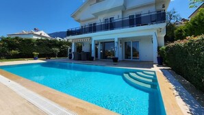 Una casa moderna de dos pisos con piscina delantera.