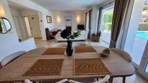 Un comedor con una mesa de madera, cuatro sillas y manteles individuales.