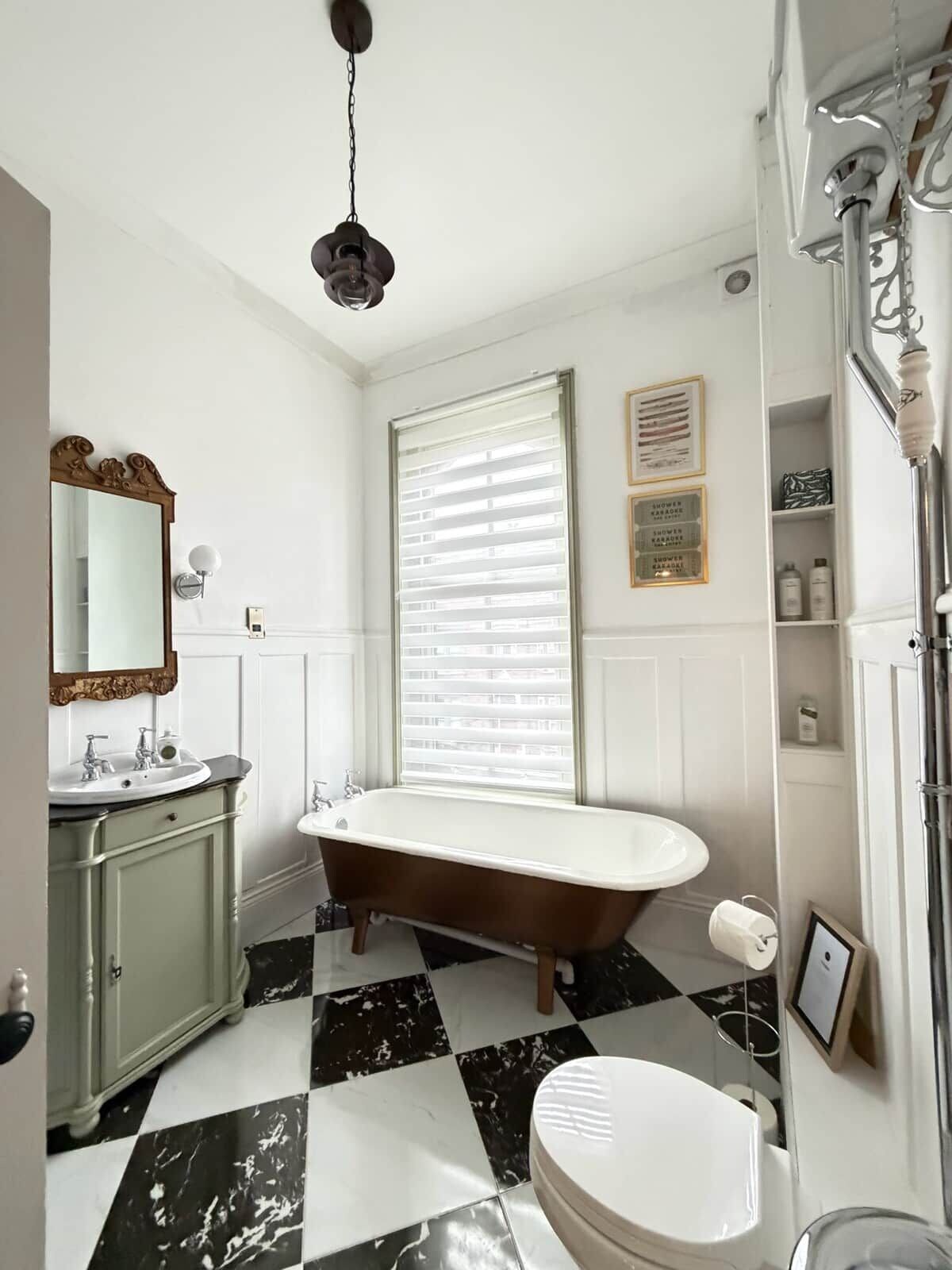 A bathroom with a freestanding bathtub, a toilet, a sink, and a vanity.