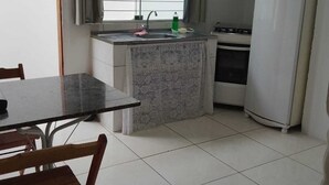 A compact kitchen with a marble countertop, a sink, a stove, and a refrigerator. - casa/kitnet em São Jose na grande Florianópolis para ate 4 pessoas (São José)