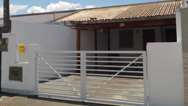 A gated property with a tiled roof and a white exterior wall. - casa/kitnet em São Jose na grande Florianópolis para ate 4 pessoas (São José)