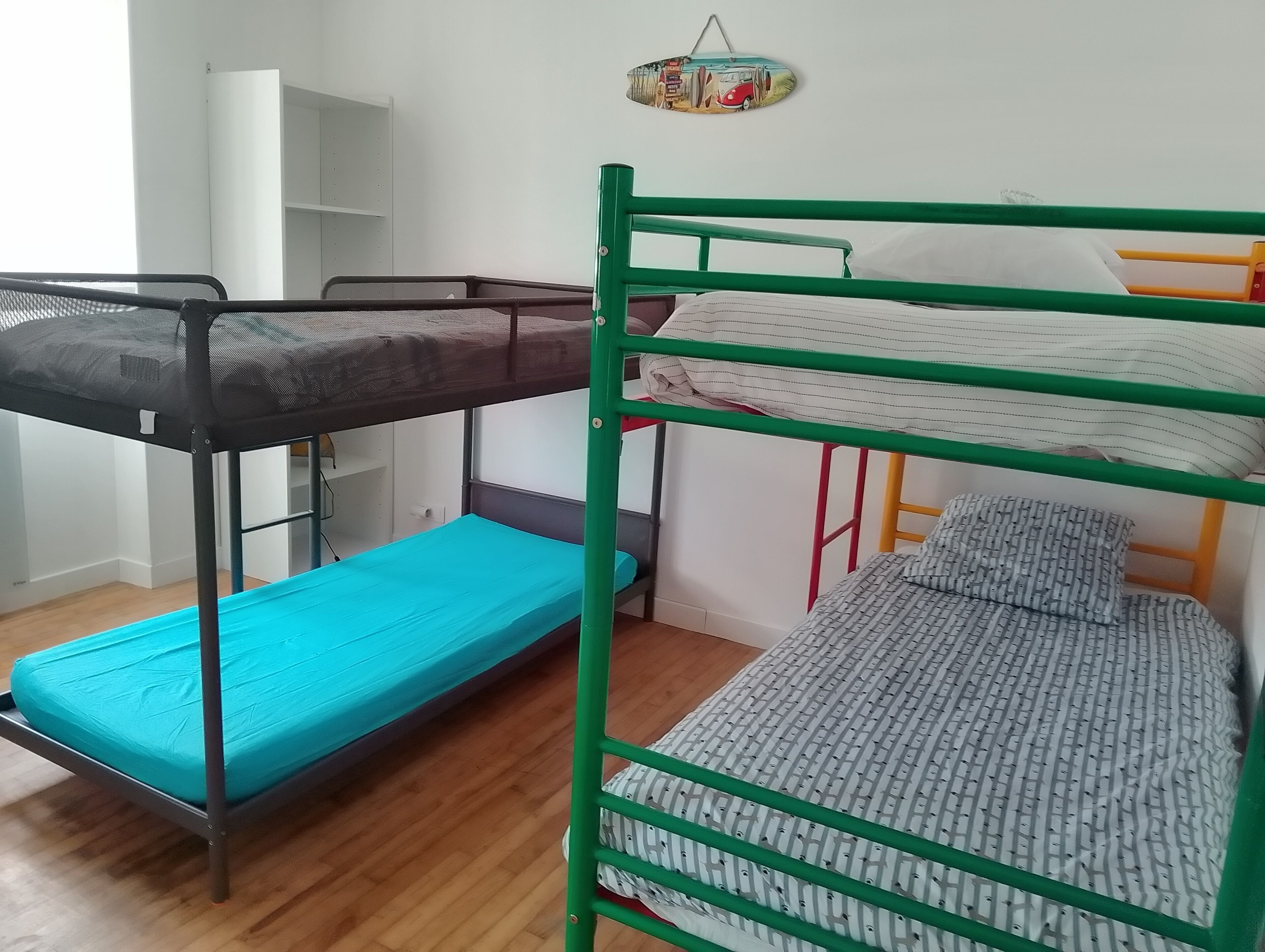 A bunk bed room with a blue mattress on the lower bunk and a grey patterned mattress on the upper bunk.