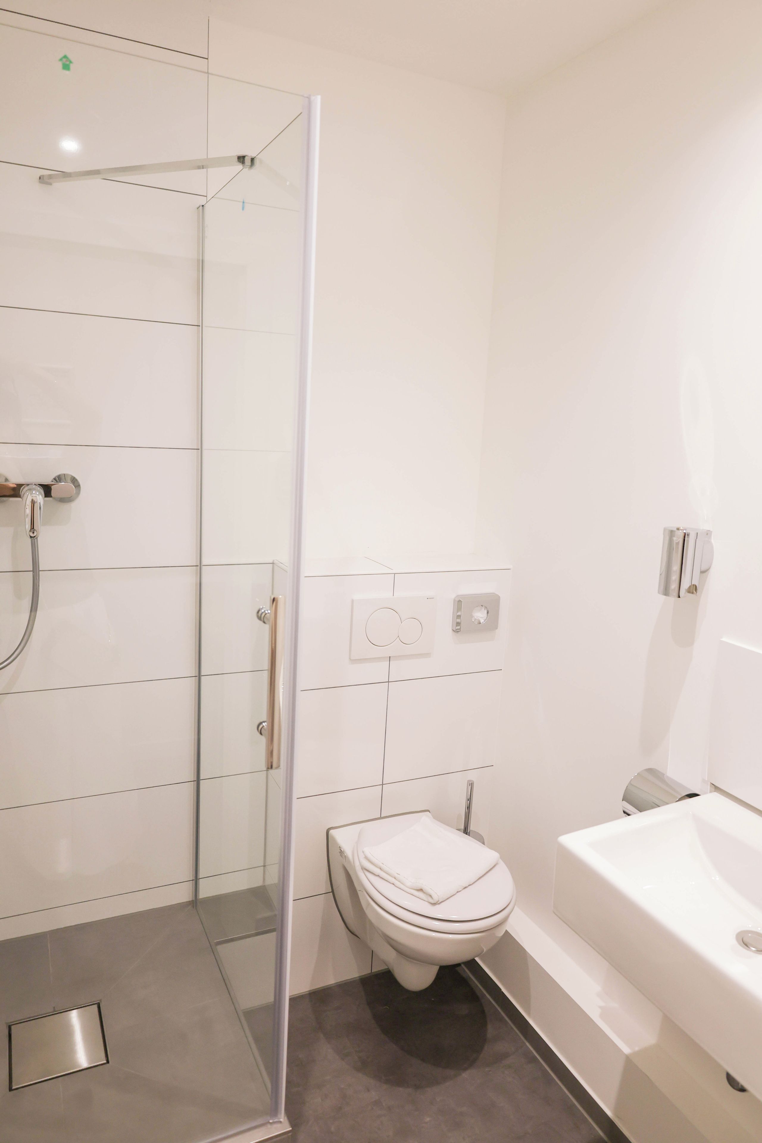 A modern bathroom with a glass-enclosed shower, a toilet, and a bathtub.