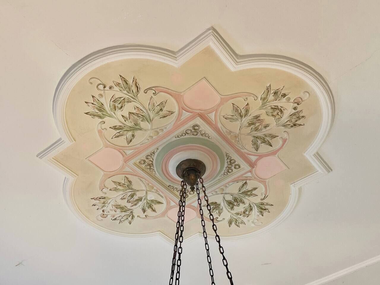 A ceiling with a floral pattern and a central light fixture.