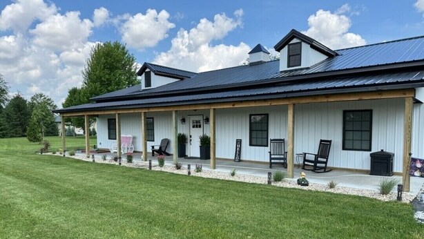 A large, single-story building with a covered porch, a chimney, and a well-maintained lawn. - Farmhouse Retreat
5 minutes from Ruoff Music Center (Pendleton)