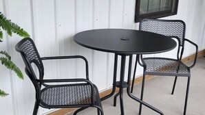 A round table with two black metal chairs, a white corrugated wall, and a window with blinds. - Farmhouse Retreat
5 minutes from Ruoff Music Center (Pendleton)
