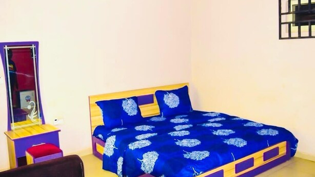 Un dormitorio con cama, un escritorio pequeño y un espejo.