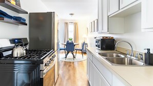 A modern kitchen with a gas stove, stainless steel sink, and a microwave. - Cute & Cozy Ferndale Duplex (Ferndale)