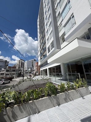 Un edifici modern amb diverses plantes, grans finestres i un terrat pla.
