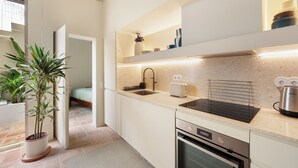 Een moderne keuken met een spoelbak, broodrooster en waterkoker, en een potplant.