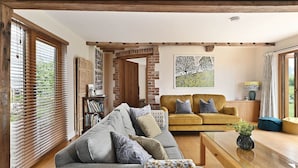 A living room with a sofa, a coffee table, and a yellow couch. - Little Hare Oast -  large home for smaller groups with amazing views (Rye)
