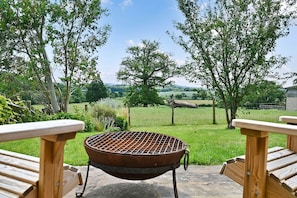 A barbecue grill in a garden with wooden chairs and a view of a rural landscape. - Little Hare Oast -  large home for smaller groups with amazing views (Rye)
