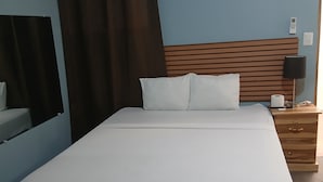 A standard hotel room with a bed, a nightstand, a lamp, and a mirror. - Casa de Huespedes Noche de Luna (San Salvador)