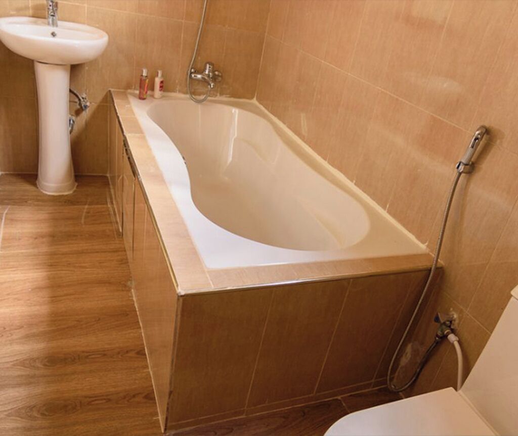 A bathroom with a freestanding bathtub, a pedestal sink, and a shower area.