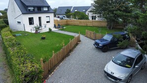 A residential area with a white house, a gravel driveway, a blue car, and a silver car parked in front. - Completely renovated Breton house - Walking distance to the beach - Sleeps 8 (Penmarch)