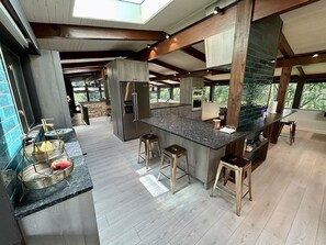 Una cocina moderna con una isla central, vigas de madera y un tragaluz.