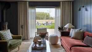 A living room with a sofa, armchair, and a table with decorative items.