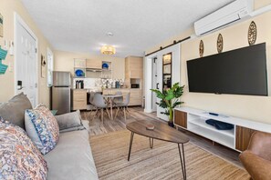 Una sala de estar moderna con un sofá, una mesita de centro y un televisor de pantalla plana.