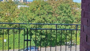 Un balcone con vista su un parcheggio e un edificio in lontananza.