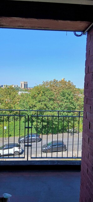 A balcony with a view of a parking lot and a building in the distance. - Cozy 2-bedroom Apartment in Central London (London)
