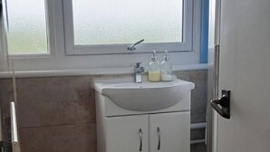 Un bagno con finestra, lavandino e piastrelle decorative.