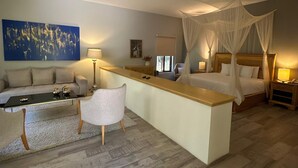 Ein modernes Schlafzimmer mit Bett, Nachttischen, einem Schreibtisch, einem Stuhl und einem großen Gemälde an der Wand.