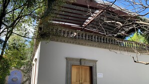 Ein Gebäude mit einer Holztür, einem Balkon mit einer Brüstung und einer Wand mit Kachelverkleidung und geometrischem Muster.