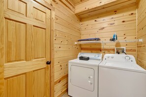 Ein Waschbereich mit Holzwänden, einer Waschmaschine und einem Trockner.