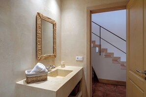 Ein Badezimmer mit Waschbecken, Spiegel und Korbwannen.