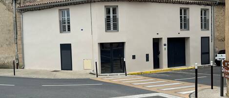 Un edificio con techo de tejas, una puerta grande y una ventana pequeña.