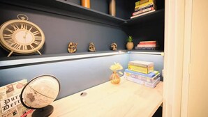 Een bureau met een wereldbol, boeken en decoratieve objecten.