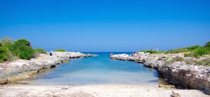 A coastal landscape with rocky shores and clear blue water. - Charming rooftop apartment just 20 m from the sea with a fantastic sea view (Villanova Ostuni)