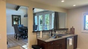 A modern kitchen with a large window, dark wooden cabinets, and a granite countertop. - Deep water, private dock, beautiful sunsets, fishing, kayaking or boating. (Gainesville)