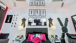 Una camera da letto moderna con un letto, due comodini, una televisione e una ventola a soffitto.