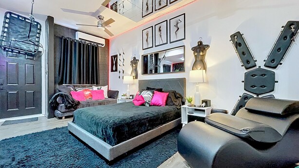 Una camera da letto moderna con un letto, comodini, una cassettiera e una ventola a soffitto.