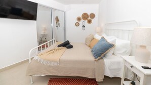 Un dormitorio con cama, mesita de noche, lámpara y decoración en la pared.