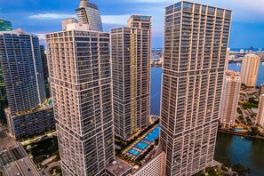 A high-rise building with a modern architectural design, featuring a prominent vertical structure and a rooftop pool. - Miami Getaway | Icon Brickell 1BR in Downtown (Miami)