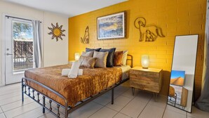 Een slaapkamer met een bed, nachtkastje en spiegel.